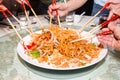 A group of people mixing and tossing Yee Sang dish with chop sticks. Yee Sang is a popular delicacy taken during Chinese New