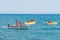 Group of people in motor boat and riding banana boat