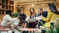 Group of People from Multiple Ethnicities Working on Problem Solving Using Notes, Laptop and Tablet Royalty Free Stock Photo