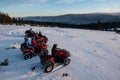 Group of people on off-road four-wheelers ATV bikes in the the mountains in winter evening Royalty Free Stock Photo