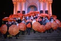 Group of people outdoor holding orange umbrellas in hands. Flashmob dedicated to International Day for Elimination of