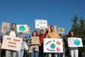 Group of people with posters protesting against climate change outdoors Royalty Free Stock Photo