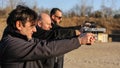 Group of people practice gun shoot on target on outdoor shooting range Royalty Free Stock Photo