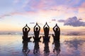 Group of people practicing meditation and yoga, beach, sunset, harmony