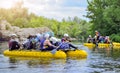 A group of people rafting on a stormy river in the yellow rafts fully loaded with personal belongings. Myhiya, Ukraine -