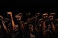 Group of people raised their hands in the air with black background, Black fists raised for equality, AI Generated