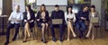 Group of people reading or using laptop computers while waiting for business meeting