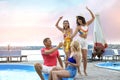 Group of people with refreshing drinks enjoying fun pool party