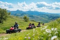 A group of people riding ATVs on a scenic mountain trail under a blue sky Royalty Free Stock Photo