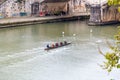 Group of people rowers canoeing in the waters of Tiber River in Rome
