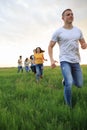 Group of people running in the grass, Royalty Free Stock Photo