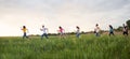 Group of people running in the grass, Royalty Free Stock Photo