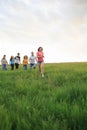 Group of people running in the grass, Royalty Free Stock Photo