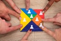 Group Of People`s Hand On Colorful Tangram Puzzle Blocks