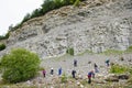 Group of people searching for ammonite fossils in limestone.