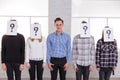 A group of people with sheets with question marks on their faces except a guy with a smile Royalty Free Stock Photo