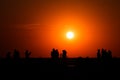 Group of people silhouettes taking photos at Sunrise, in Eforie Nord. Royalty Free Stock Photo