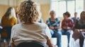 A group of people is sitting in a circle, engaged in a therapy meeting. They are actively listening, sharing personal Royalty Free Stock Photo