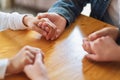 Group of people sitting in a circle holding hands and pray or in therapy session Royalty Free Stock Photo