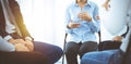 Group of people sitting in a circle during therapy in sunny office. Meeting of business team participating in training Royalty Free Stock Photo