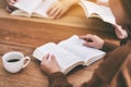 People sitting and enjoyed reading books together on wooden table