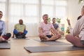 Group Of People Sitting On Exercise Mats Meeting For Fitness Or Yoga Class In Community Center Royalty Free Stock Photo