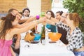 Group of people sitting having lunch together and toasting Royalty Free Stock Photo