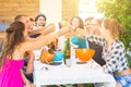 Group of people sitting having lunch together and toasting Royalty Free Stock Photo