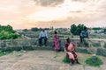 A group of people sitting quietly on the ramparts of the ancient Vellore Fort complex