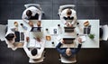 A group of people sitting at a table working on laptops