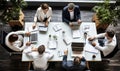 A group of people sitting at a table working on laptops