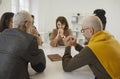 Group of people sitting together around table with Holy Bible and praying to God Royalty Free Stock Photo