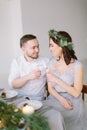 Pretty bridesmaid in pine wreath and groomman at the wedding table drink champagne. Group of people sitting at wedding