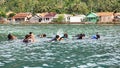 Group of people snorkling near a traditional fishermen village