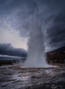 people watch as a water spews from a crater