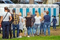Group of people standing near portable toilets