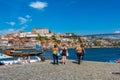 Group of people standing near a riverbank in a picturesque town