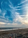 Group of people standing on the sandy beach and having fun playing with colorful kites in summer Royalty Free Stock Photo