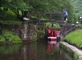 A group of people taking a narrowboat though a lock gate on the rochdale canal in hebden bridge west yorkshire Royalty Free Stock Photo