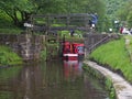 A group of people taking a narrowboat though a lock gate on the rochdale canal in hebden bridge west yorkshire Royalty Free Stock Photo