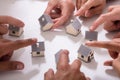 Group Of People Touching Miniature House