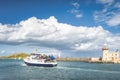 Group of people on a tour boat in Howth marina with Howth Lighthouse and Irelands Eye island in background