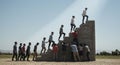 A group of people of various ages interact with a large, concrete stair structure in an Royalty Free Stock Photo