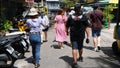 A group of people walk in a Bangkok alley