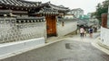 Group of people walking along a busy street in Bukchon Hanok Village, Seoul