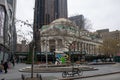 Group of people walking along a city sidewalk, passing by urban buildings in New York, United States