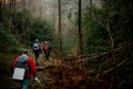 Group of people walking with backpacks in the dark forest Royalty Free Stock Photo