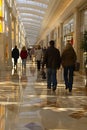 A group of people walking down a long walkway in the mall, AI