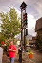 people walk past the clock tower on a quiet street in the small town