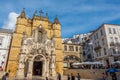 Group of people are walking in front of the Monastery of the Holy Cross in Coimbra